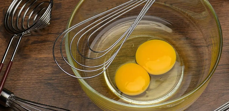 fouet plat acier inox dans un bol avec oeufs